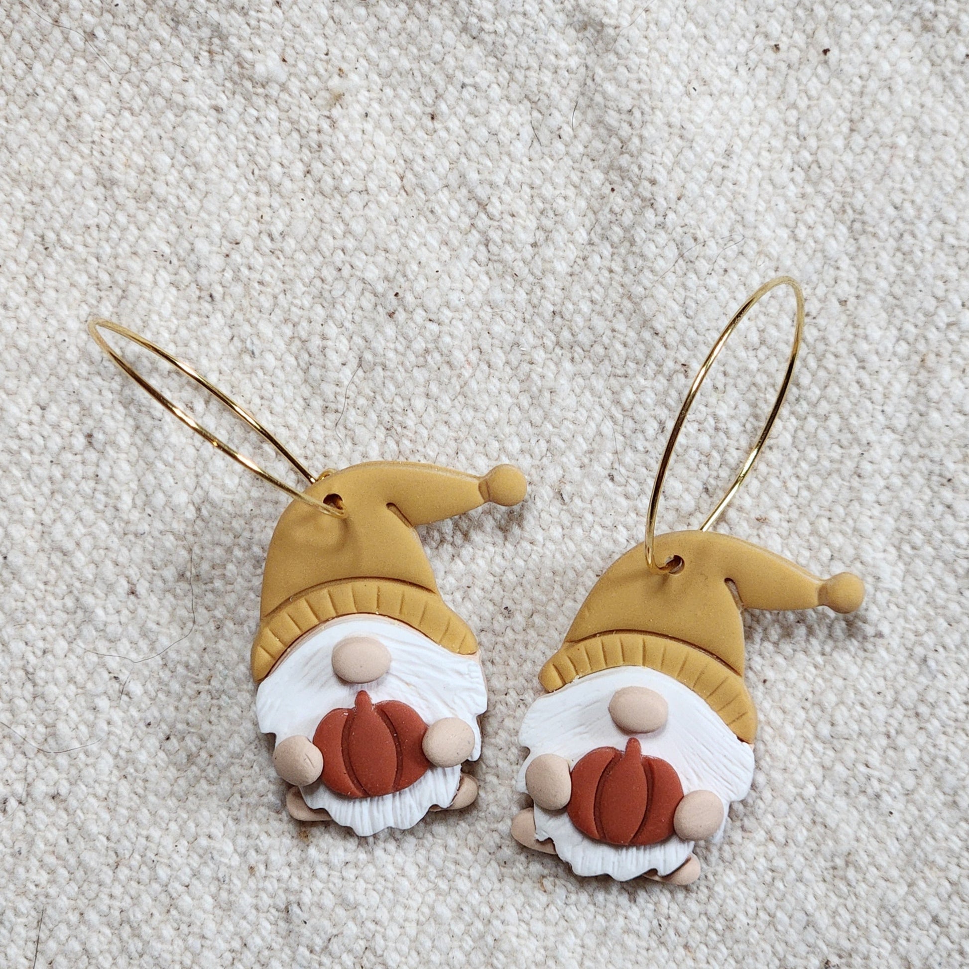 Pair of fall gnomes with yellow hats and willowy beards holding pumpkins