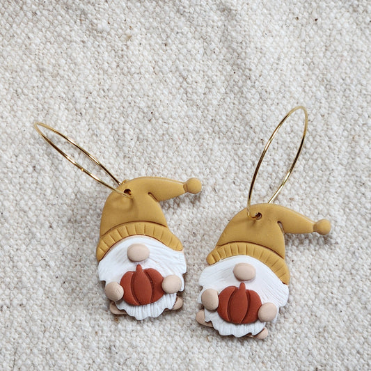 Pair of fall gnomes with yellow hats and willowy beards holding pumpkins