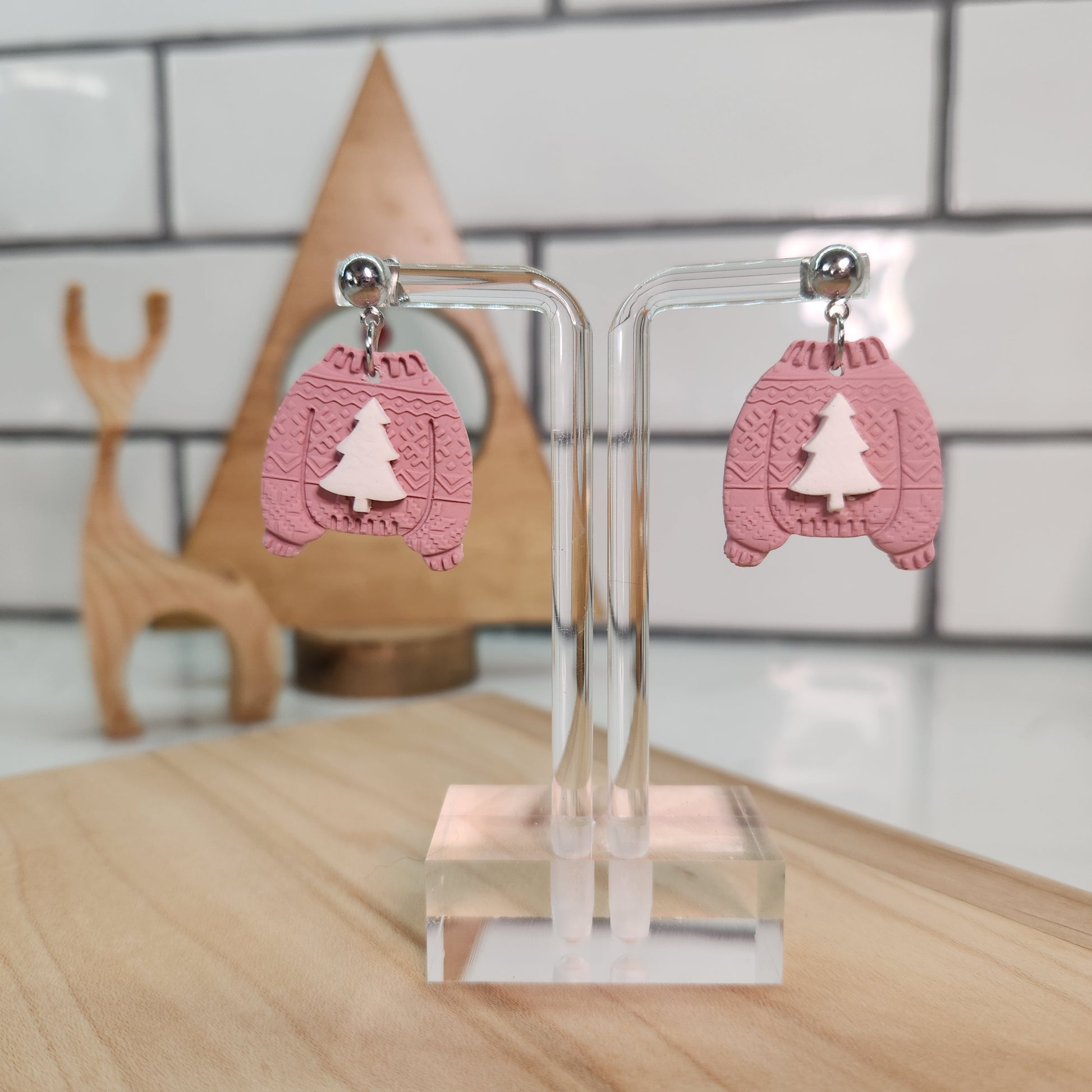 Christmas pink sweater earrings with a white Christmas tree.